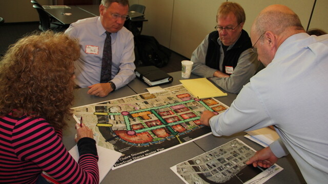 THEY AIN’T PLAYIN’ MONOPOLY. A November 1 “visioning session” with about 25 downtown Eau Claire stakeholders asked attendees to discuss how to better handle things like green spaces, connectivity, anchors, and image. Above: Phil Johnson of Ayres Associates leads a brainstorm on parking. 