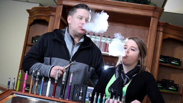 NOT WAITING TO EXHALE. E-Cig 53 owner Kyle Anderson and his girlfriend, Nicole, demonstrate electronic cigarettes, which simulate smoking via inhaled vapor containing nicotine and flavoring.