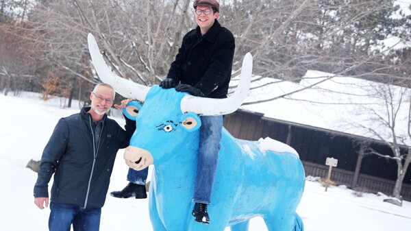 TAKE THE BULL TO EAU CLAIRE. Nate Snipe from Pert’ Near Sandstone and Jim Bischel, the president of Country Jam, hang out with Babe the Blue Ox in Carson Park.