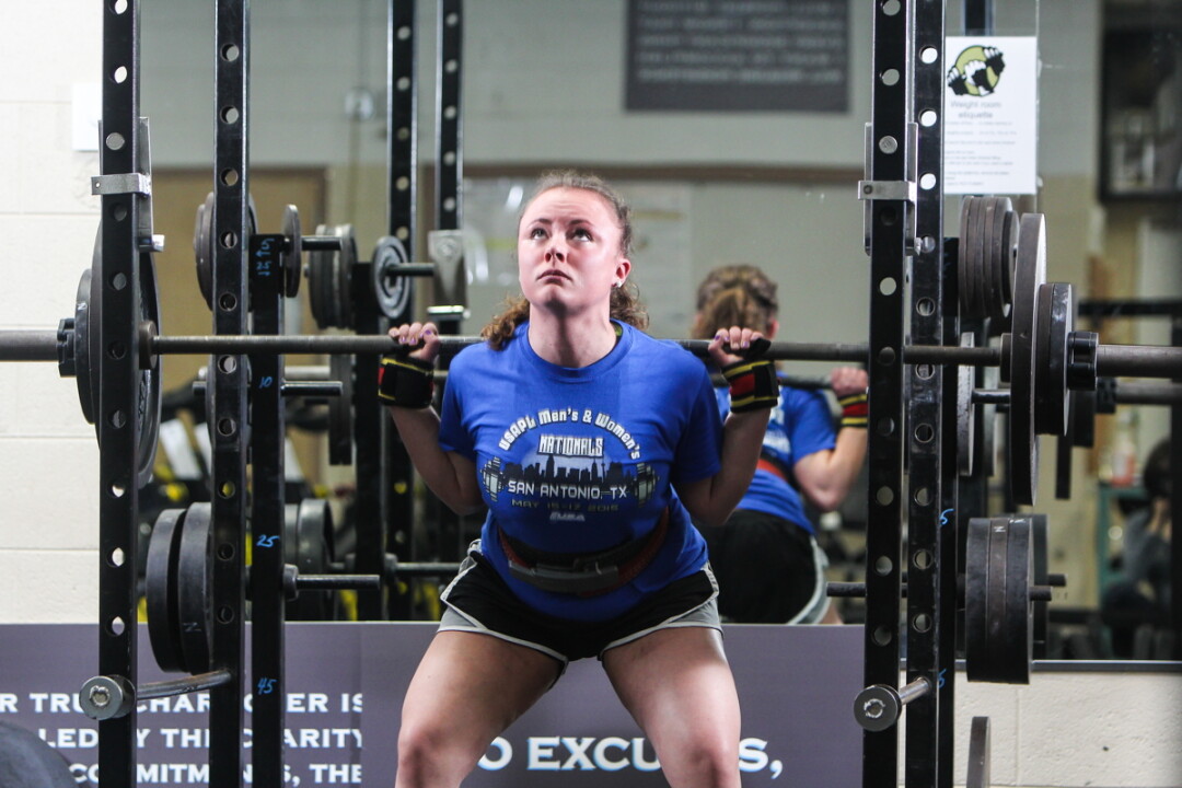 PREMIER POWERLIFTERS. We’re not sure exactly how much weight North High School powerlifter Sam Kroll is lifting in these photos, but it’s probably a ton. Yeah? Can we agree on a ton? She’ll be heading to the World Powerlifting Championships in the Czech Republic with her coach, Mariah Hamm (above, spotting).