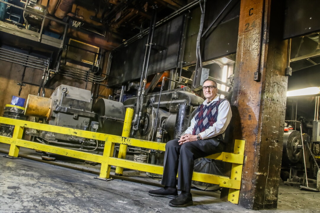 EXPLORING THE FACTORY.Jack Zais, who worked in maintenance at the tire plant for 25 years, sits before a Banbury mixer, for which the building was named.