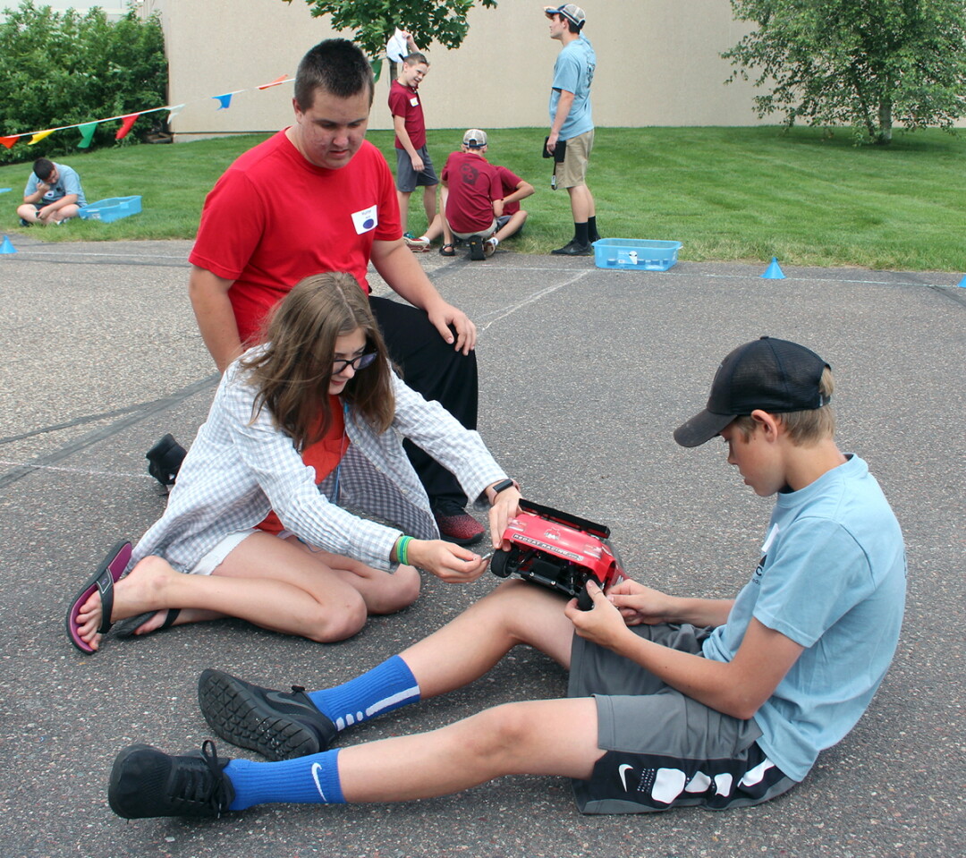 CVTC STEM Race Camp participants, from left, Hunter Moritz of Menomonie, Rebecca Hansen of Brooklyn Center, Minn., and Evan Eslinger of Chippewa Falls, work together to make adjustments to their car in preparation for the final races, at the CVTC Manufacturing Education Center June 21.