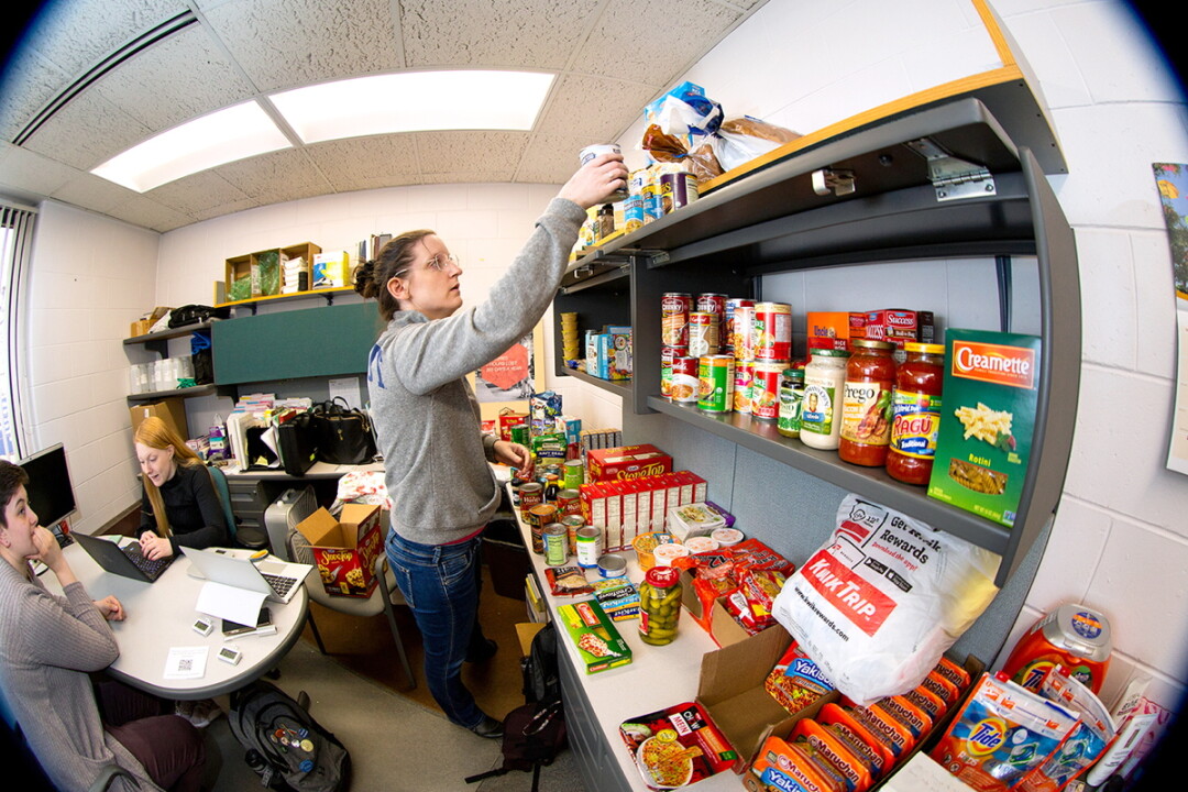 HELPING ON THE MENU. Sarah Snyder, UW-Stout residence life coordinator, stocks shelves at Helping Hand food plus pantry in the University Services building at UW-Stout.