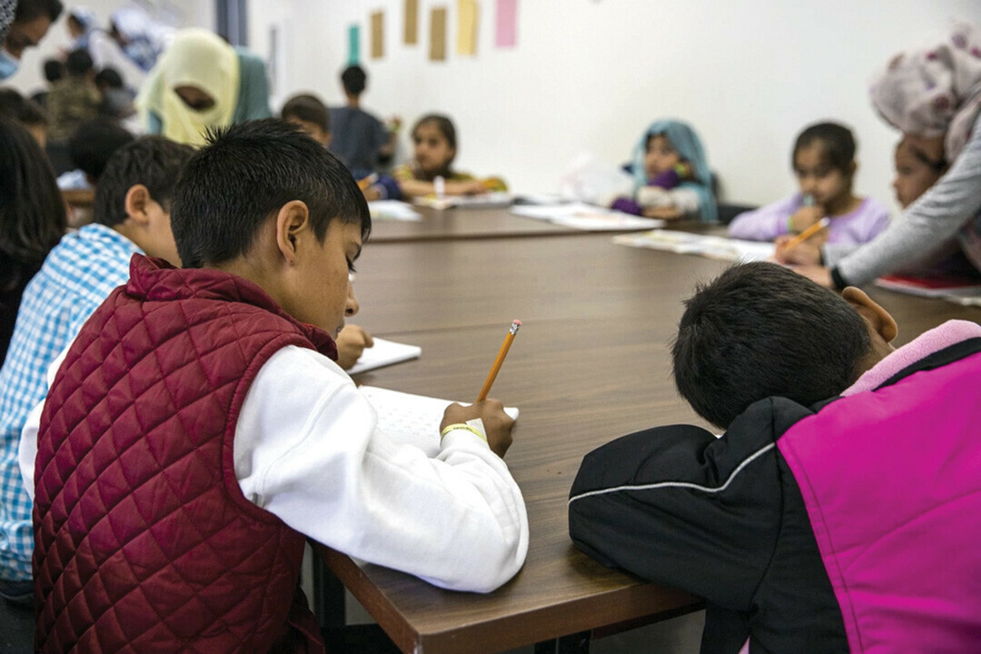 THE WRITE STUFF. Afghan children attended school at Fort Mc Coy, Wisconsin, in 2021. Some of these refugees have gone on to settle around the state, including in Eau Claire. Now, the community is again preparing to welcome new refugees.