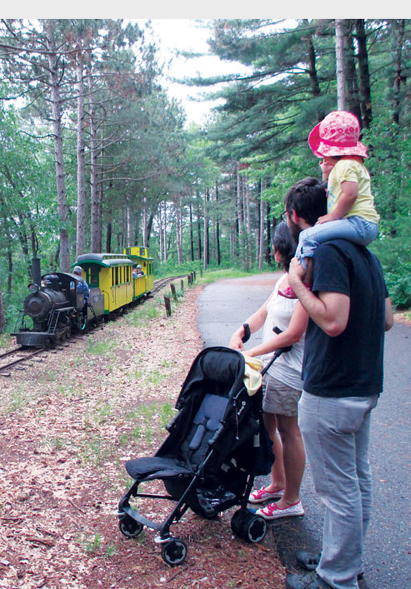 It’s rolling ’round the bend. Jacob and Francesca Zinn and their daughter, Teodora, watch as the Chippewa Valley Railroad Association’s coal-powered steam train chugs on down the track.