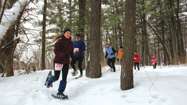 OVER THE RIVER AND THROUGH THE WOODS. On Saturday, Jan. 29, The Powder Keg Snowshoe Race hosted runners on two courses at Lowes Creek County Park. Two-milers, pictured here, as well as the more hardcore five-milers, trudged their way around the hills and valleys of the popular wooded area.