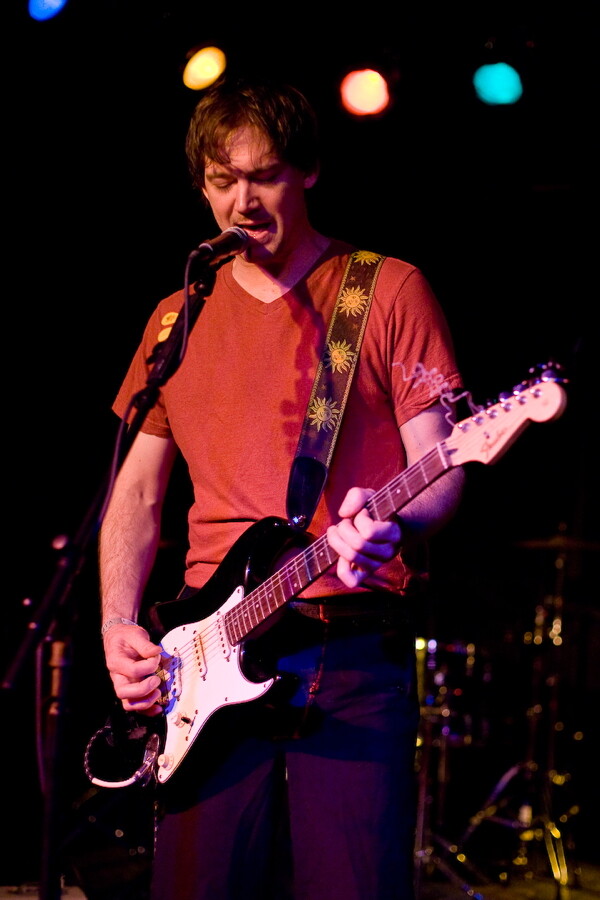 Nick Arnold, singing and playing the guitar simultaneously.