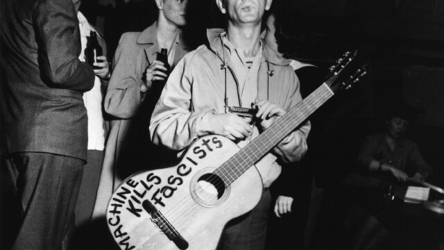 BELOW: Woody Guthrie, shown here sticking it to the man.