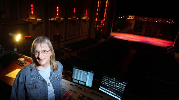 ALL THE WORLD’S A STAGE, SO LET’S KEEP IT PROPERLY LIT. Local light designer Paula Dinkel stands before The State Theatre’s light board.