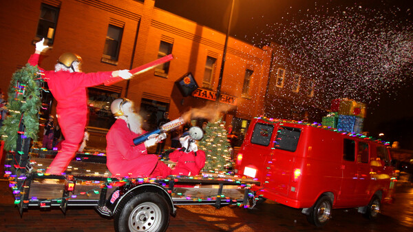 HERE WE GO A-LAUNCHERING. The first-ever Clearwater Winter Parade was held Saturday, December 15. Roughly 5,000 people turned out at 5pm to watch 48 light-covered parade entries make their way down Water Street in Eau Claire. Seen here is Volume One’s festive 1967 V1 Van pulling a crew of five Santas in red jumpsuits and sparkly helmets – The Holly Jolly Action Squad – while they launch teddy bears and confetti, hand out candy canes, and high-five parade goers.