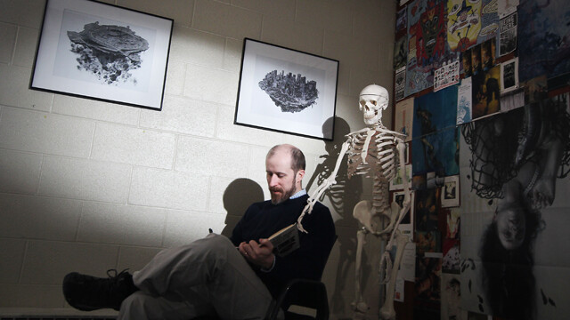 MAIN full horiz - Ned-Gannon-Sketching-2.jpg 2013-02-26 14:56:47 DEAD MAN DRAWING. Illustrator Ned Gannon sketches in his office at UW-Eau Claire with the company of his life drawing teaching aid.