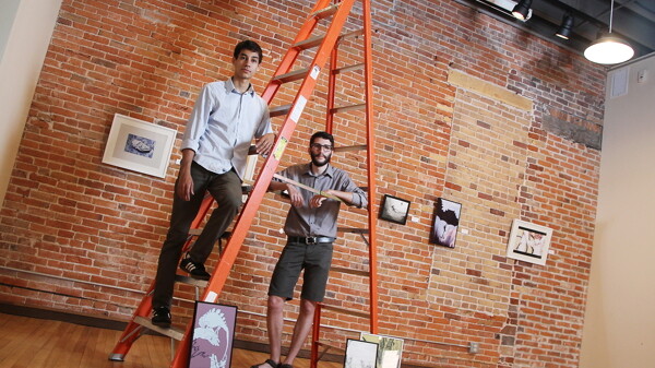 “DON’T PRETEND YOU’RE TALLER, DUDE.” Dieter McCallum (right) and Isaac Ruder pose with some of the work from their show, Summer Doldrums, at the Volume One Gallery.