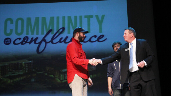Justin Vernon shakes hands with US Bank Regional President Mark Degner (with JAMF Software's Zach Halmstad looking on) after his announcement of a $100,000 pledge to the Confluence Project.