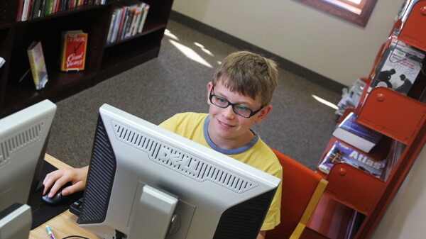 Eleven-year-old Ryder Simington uses a computer at the new Elk Mound Library.