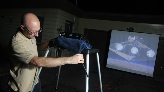 NOT LONG AGO, IN A DRIVEWAY NOT FAR AWAY ... Wade Cain of Eau Claire demonstrates his outdoor film-projecting gear, which he uses to show movies to his family, friends, and neighbors.