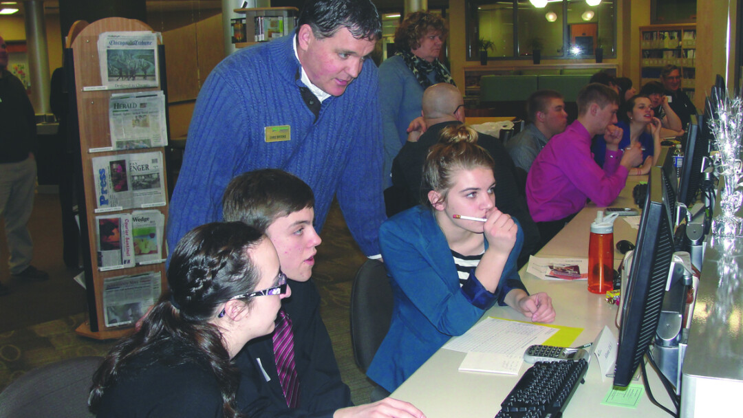 TEENS WITH SCREENS. Volunteer Chris Brooke of WESTconsin Credit Union works with local students during a Junior Achievement event at the Chippewa Valley Technical College Learning Center.  