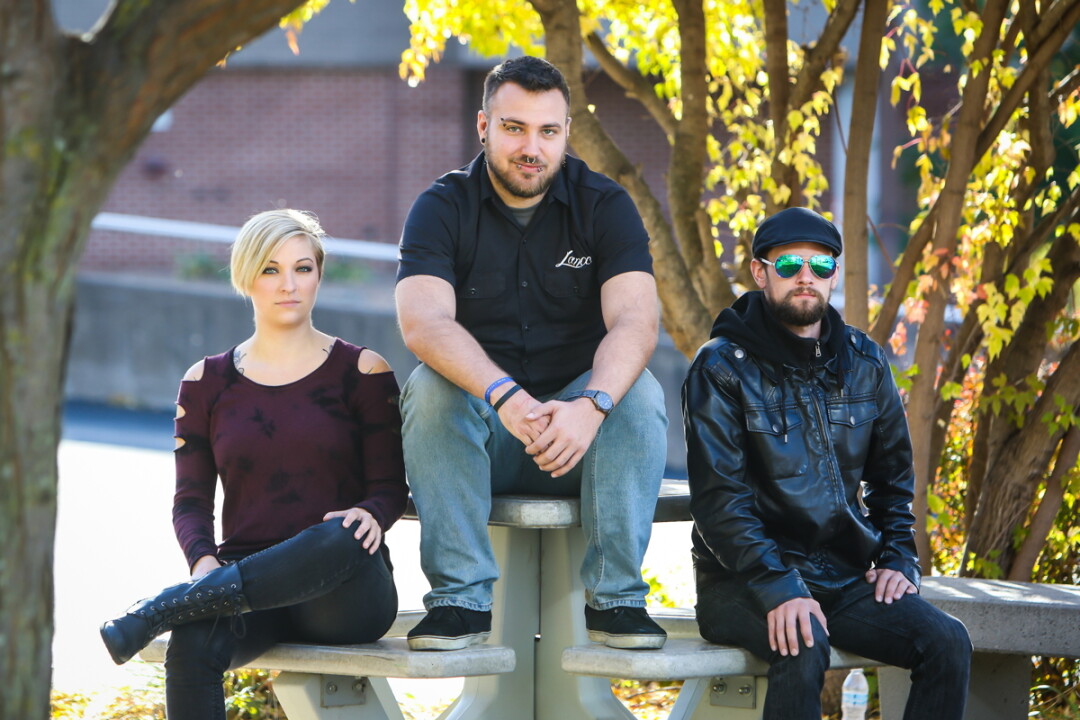 TAKING A HARD STANCE. From left to right, Christina Parker, Lance Katcher, and Rad Anthony Brown are some core members of Midwest Mayhem, a booking and promotion company that helps local bands throw shows and promote them, all in the name of building up Eau Claire’s stellar music scene.
