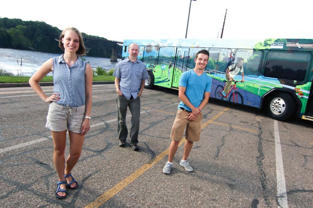 THAT’S A WRAP. UWEC students Roslyn Cashman (design) and Lukas Carlson (illustration), with professor Ned Gannon (center). And an Eau Claire city bus (background).