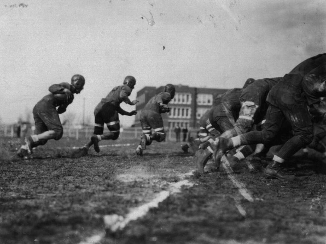 A scene from the 1929 Homecoming Football Game against Stevens Point.  Schofield Hall can be seen in the background.