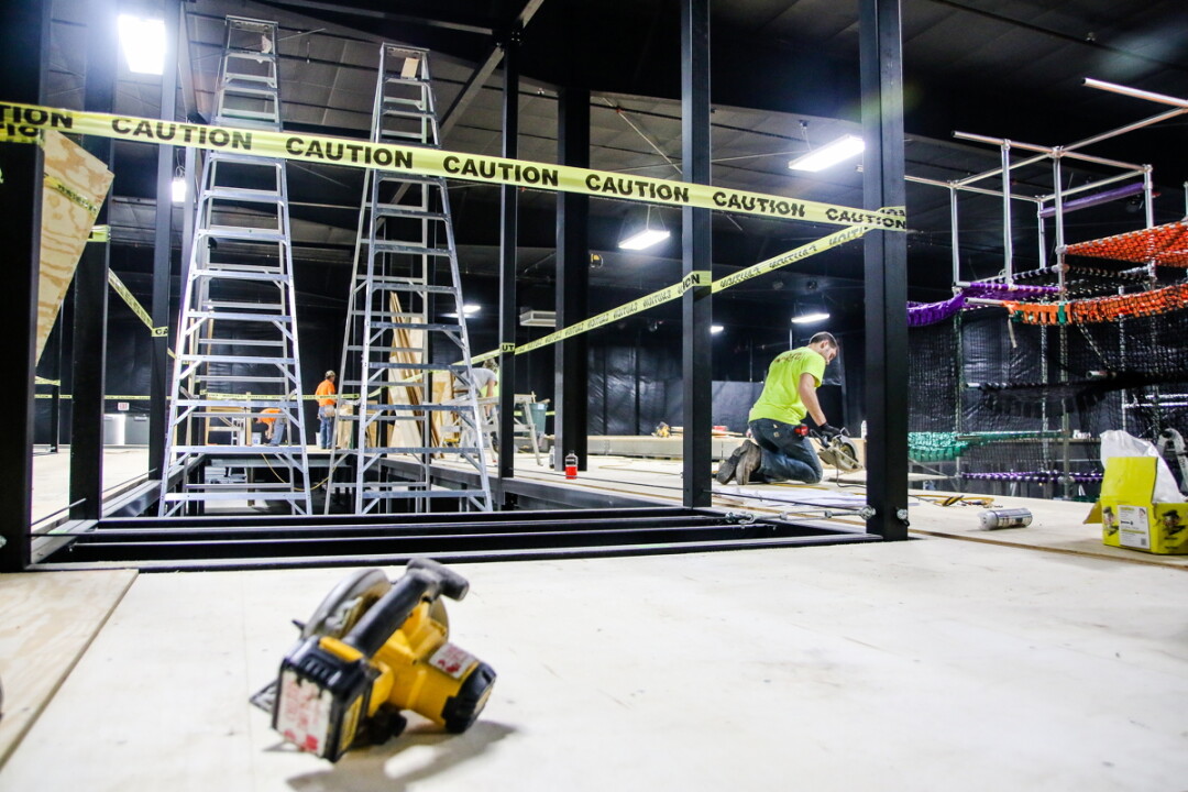CAUTION: GOOD TIMES AHEAD! Workers put the finishing touches on the new trampoline park at Action City (above), which promises to be the biggest in the Midwest. After the remodeling, Action City will still feature favorites like arcade games (right).