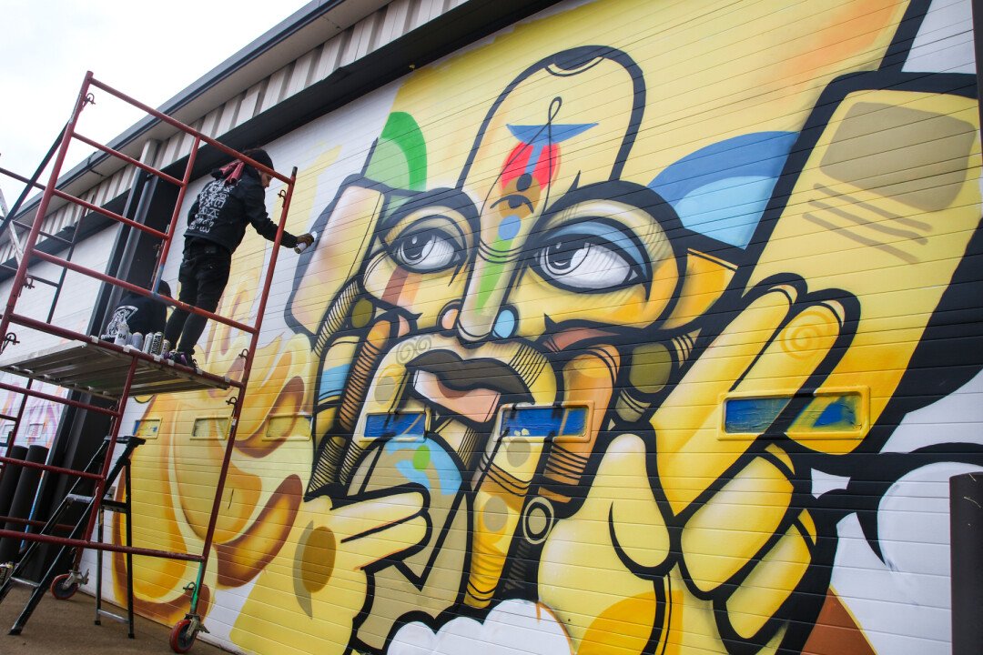 A muralist creates a new work of art during the Uptown Art Jam on Oct. 21 at Artisan Forge Studios in Eau Claire.
