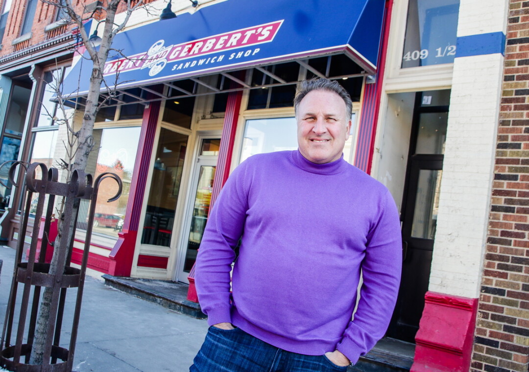 A SANDWICH SHOP SAGA. Erbert and Gerbert’s C.E.O. Eric Wolfe stands in front of the Water Street location in Eau Claire that started it all. The company now has more than 100 locations this year, their 30th anniversary.