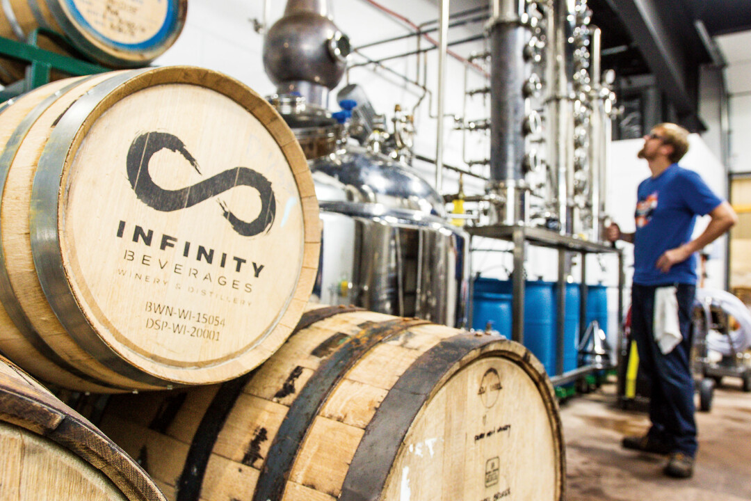 TOP: Joel Forke, production assistant, looks at the 1,000 liter still that produces vodka, whiskey, and other spirits at Infinity Beverages. ABOVE: Melissa Christianson, front of house manager, pours a complimentary taste for a visitor at the Tasting Lounge.