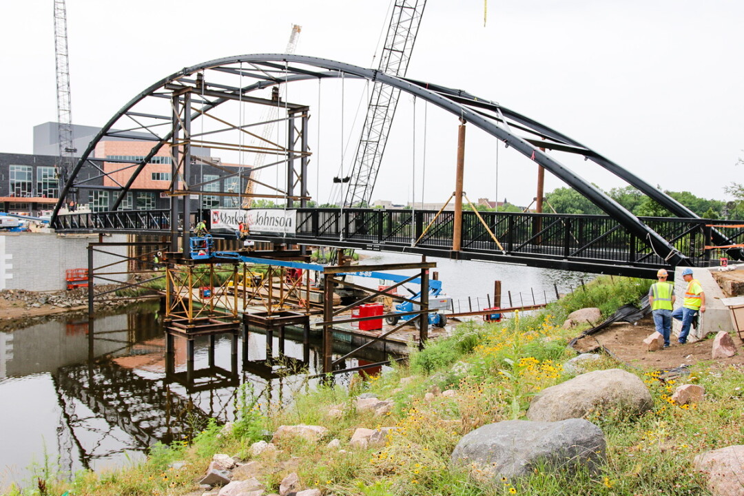 workers installed the confluence crossing pedestrian bridge las summer across the eau claire river in downtown eau claire. market & johnson served as contractor for construction of the The bridge as well as for the Pablo center at the confluence behind it.