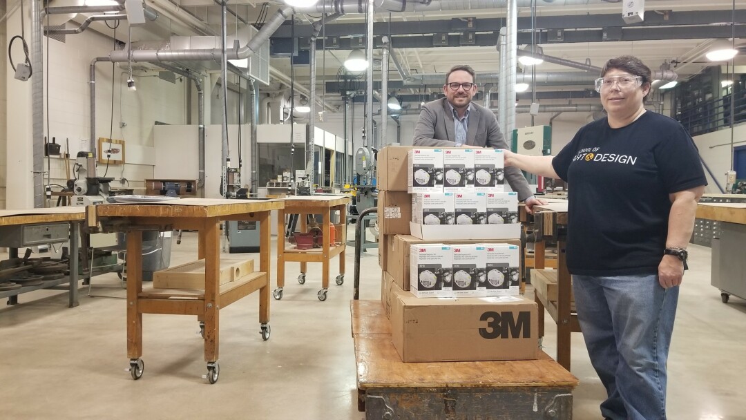 School of Art and Design Director Dave Beck, left, and Cathie Weissman, financial specialist senior and safety officer, show some of the 1,760 UW-Stout N95 masks that went to Dunn County Emergency Management to help protect medical personnel, law enforcement officers, and firefighters.