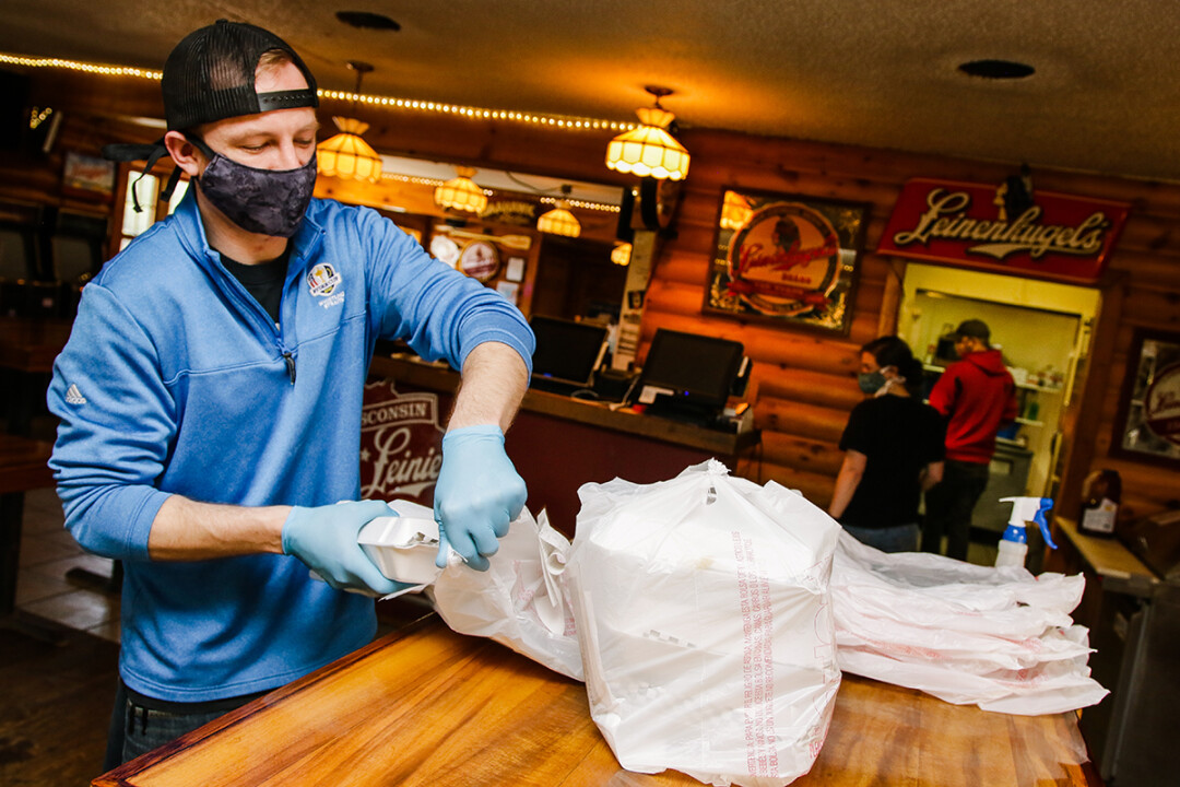 An employee at Loopy's Saloon & Grill outside Chippewa Falls prepares an order for delivery.