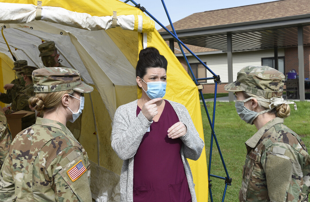 Members of the Wisconsin National Guard converse with a staff member during a COVID-19 testing event April 25 at a long-term-care facility in Lancaster, Wisconsin. (Source: Flickr | Licensed by xxx)
