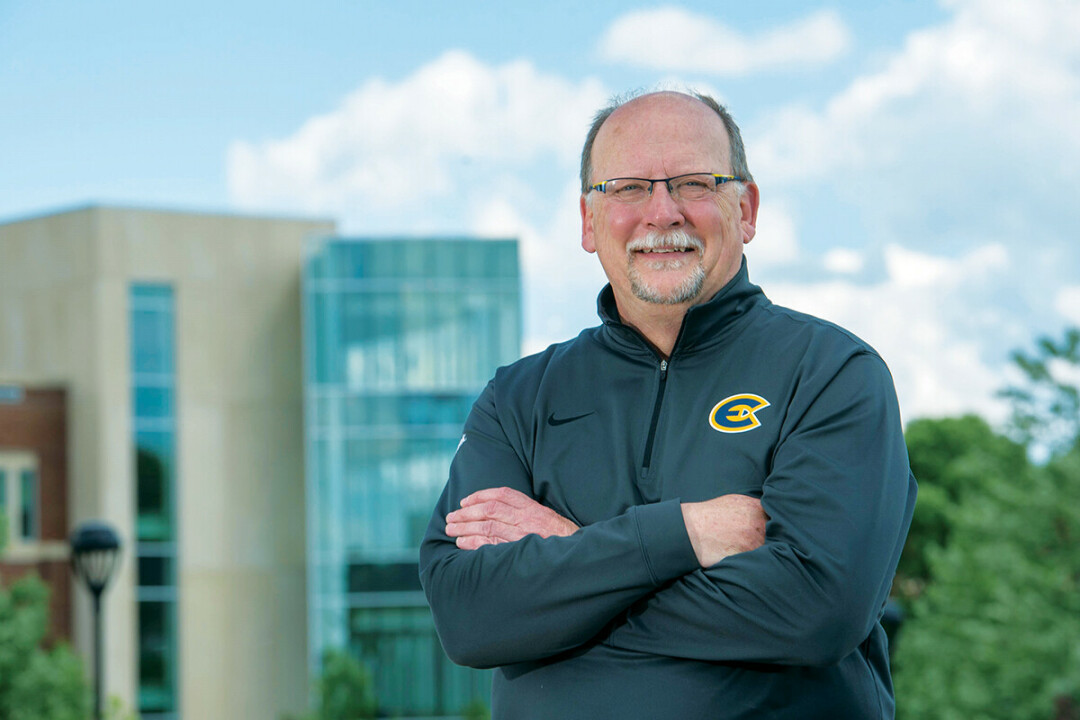 Mike Rindo poses in front of UW-Eau Claire's Centennial Hall, one of the campus buildings he helped bring into reality during his time as a university leader. (Photo: UW-Eau Claire)