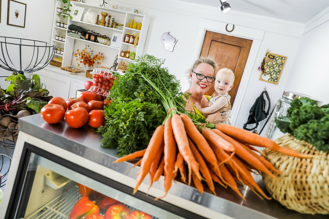 GROWING BUSINESS. Amber Georgakopoulos and her son, Leo, at the Farmers' Store in downtown Menomonie.