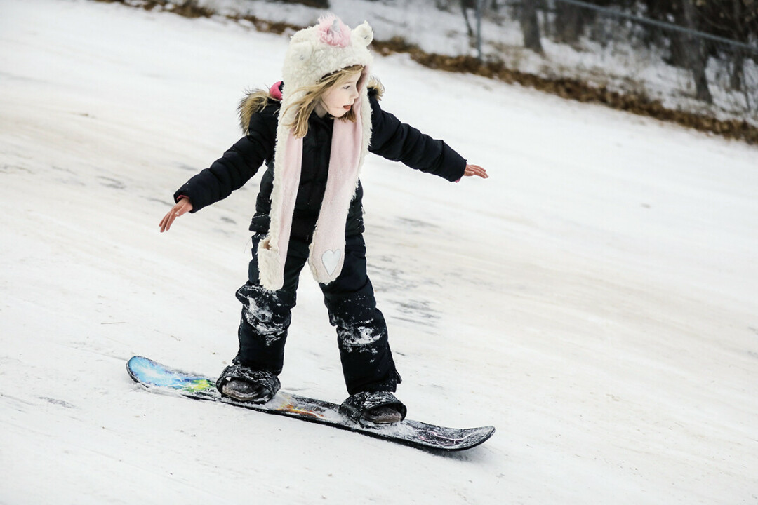 Molly Rowekamp, who is just turning 7, joins her family sledding on Seven Bumps Hill.