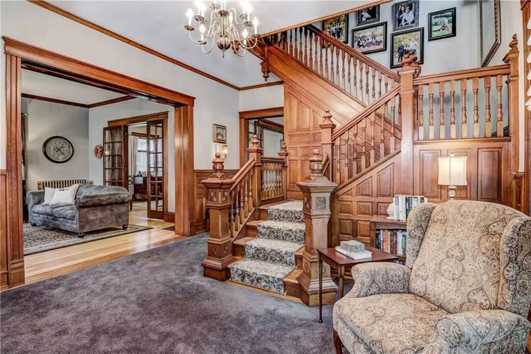 STEP INSIDE. The home's foyer features an ornate staircase to the second floor.