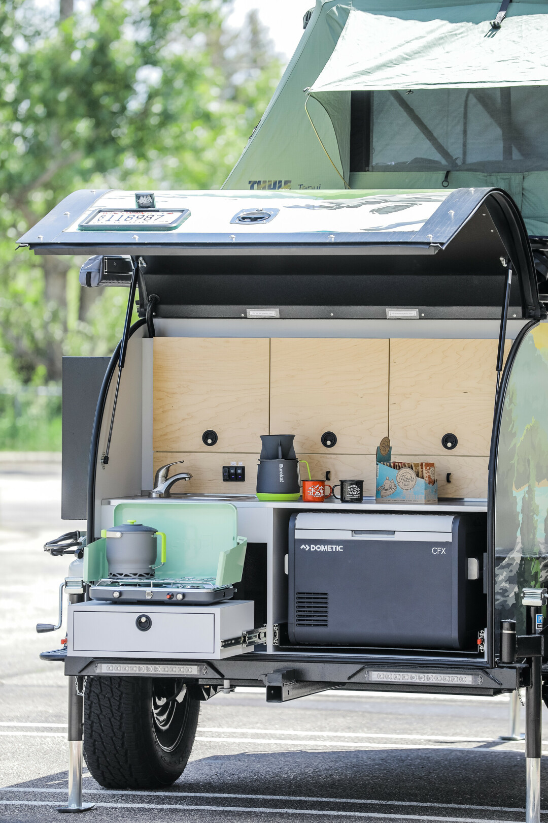 ALL SET FOR THE SUMMER. This cozy camper contains a sink, two-burner stove, air conditioning and heating, a fridge/freezer, USB cable chargers for your phone, and a propane box for hot water, offering you the chance to take hot showers on the go. Talk about 