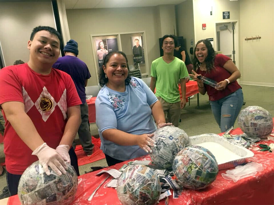 TAKING A SWING AT CRAFTING. UW-Stout students, with Latinos Unidos adviser Vickie Sanchez, make piñatas prior to COVID-19. (UW-Stout photo)