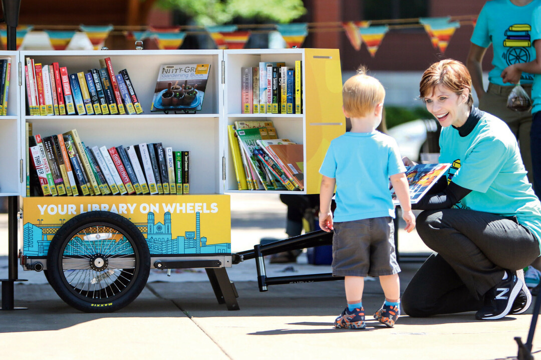 CHECK IT OUT. Outgoing L.E. Phillips Memorial Public Library Director Pamela Westby works at the library's Book Bike in this file photo.