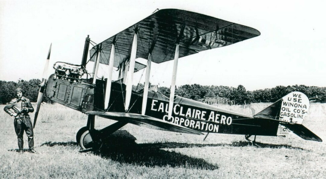 Pilot Dick Grace by airplane advertising Eau Claire Aero Corporation. 1920. CVM #524100-0013-001