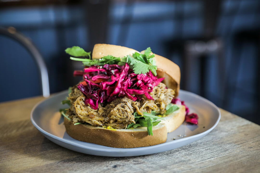 Sandwich is coffee and Chipotle rubbed Pork with pickled cabbage slaw, arugula, cilantro, and hot mustard served on Texas toast.