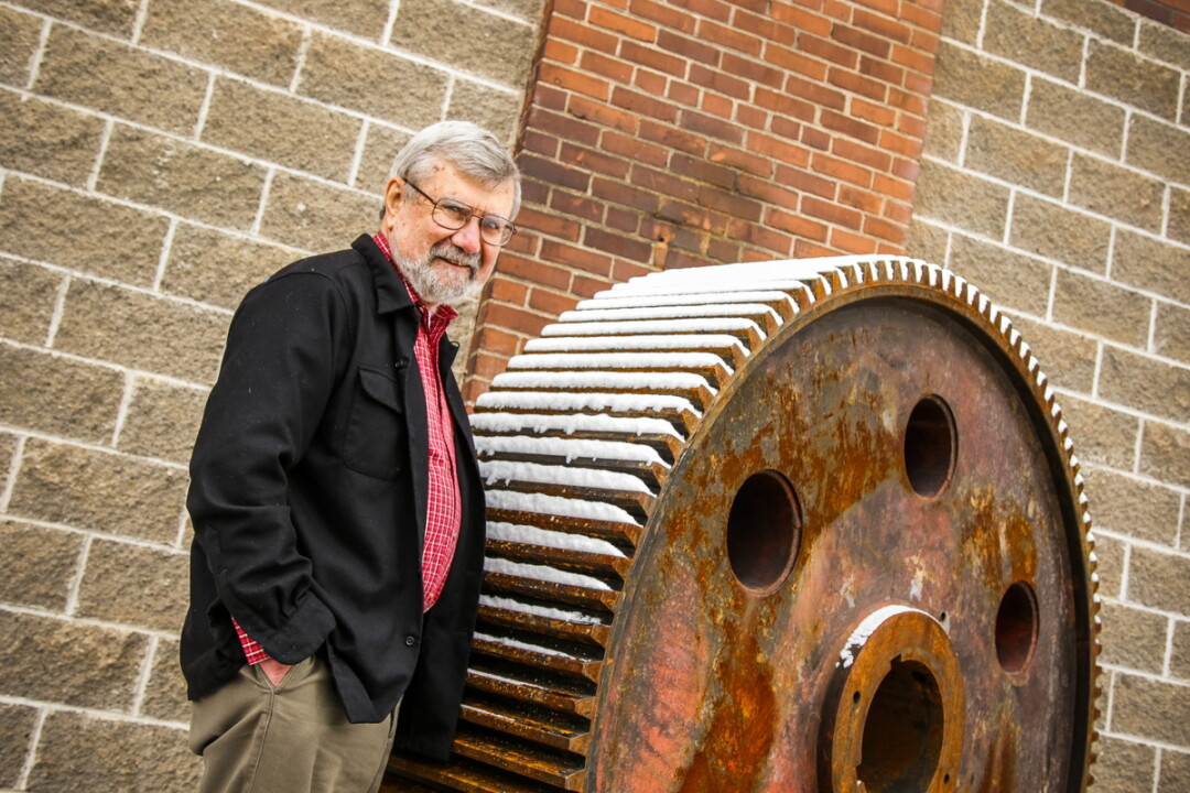 HISTORY ROLLS ALONG. Author Brian Blakeley, shown here outside Banbury Place, Eau Claire's former tire factory, has written a third volume of the city's history.