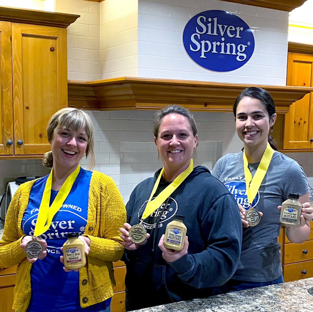 Silver Spring Foods Zing Masters holding the 2022 World-Wide Mustard Competition winning mustards (from left to right: Sarah Kolk, Judy Christensen, Victoria Neuman