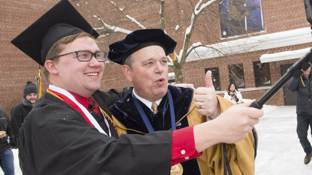 SELFIE TIME. UW-Eau Claire Chancellor James Schmidt, right, hams it up with a new grad. (Submitted photo)