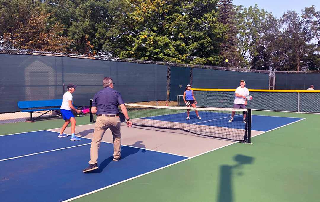 PICKLE YOUR POISON. The writer, in khakis, getting a pickleball lesson at McDonough Park. (