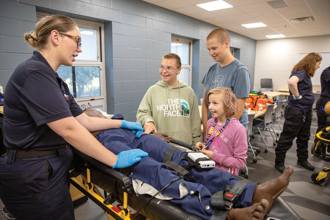 HANDS-ON LEARNING. Maesa Rydberg, left, a student in CVTC’s Paramedic Technical Diploma program, shows off one of the college’s lifelike training manikins during an open house Sept. 12.
