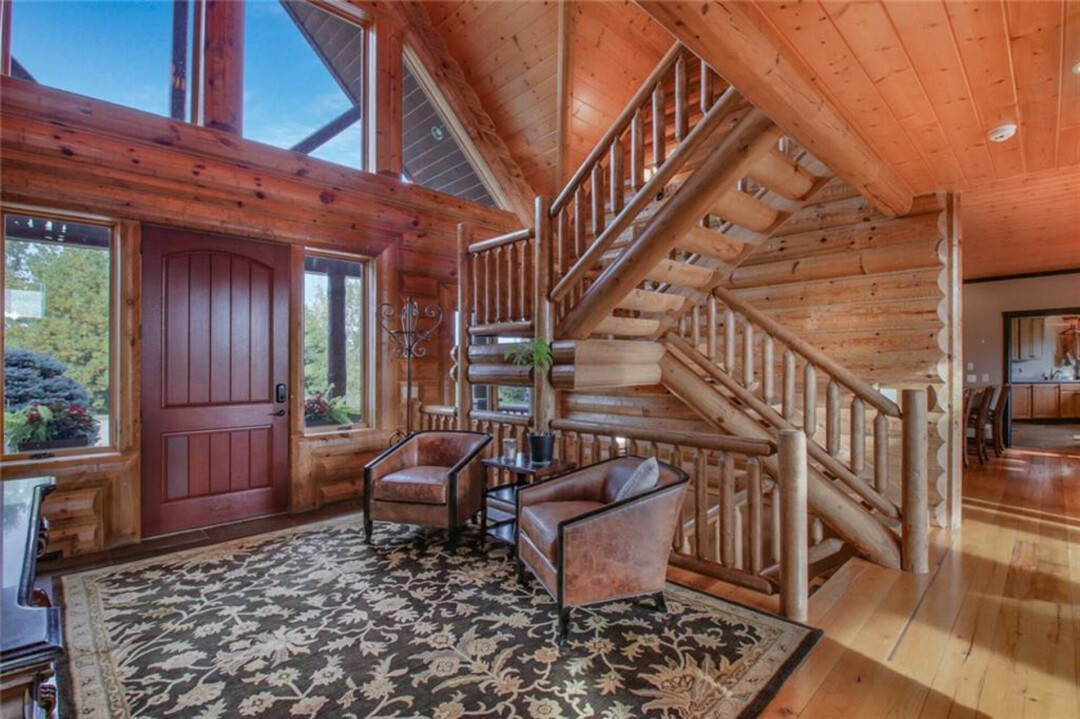 STEP INSIDE AND STEP UP. The home's foyer features an ornate staircase to the second floor.