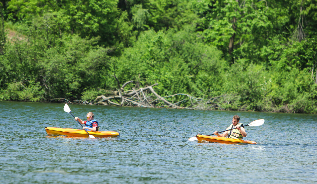 BOARDING AT BRAUN'S BAY. Or kayaking, whichever works for you! A new rental kiosk is host to kayaks and paddle boards at Braun's Bay.