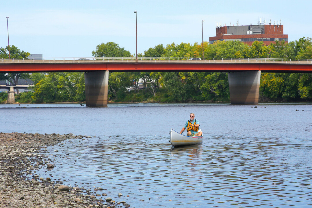 Author John Hildebrand paddling to Owen Park for the mural's dedication ceremony.