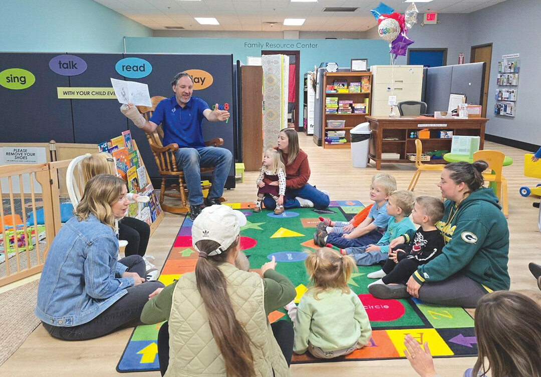 Brian Doxsie, a parent educator at the Family Resource Center, leaders a play ground.  