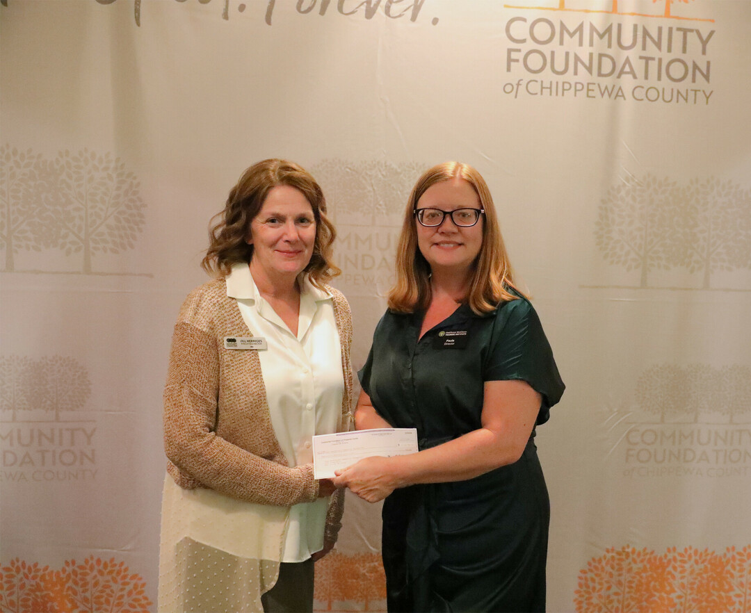 Jill Herriges of CFCC (Left) hands Paula Gibson of HWTI (Right) a Compeer Financial grant check to offer free   American Red Cross certification in Chippewa County.